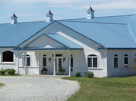 beige house with blue metal roofing|beige house with blue roof.